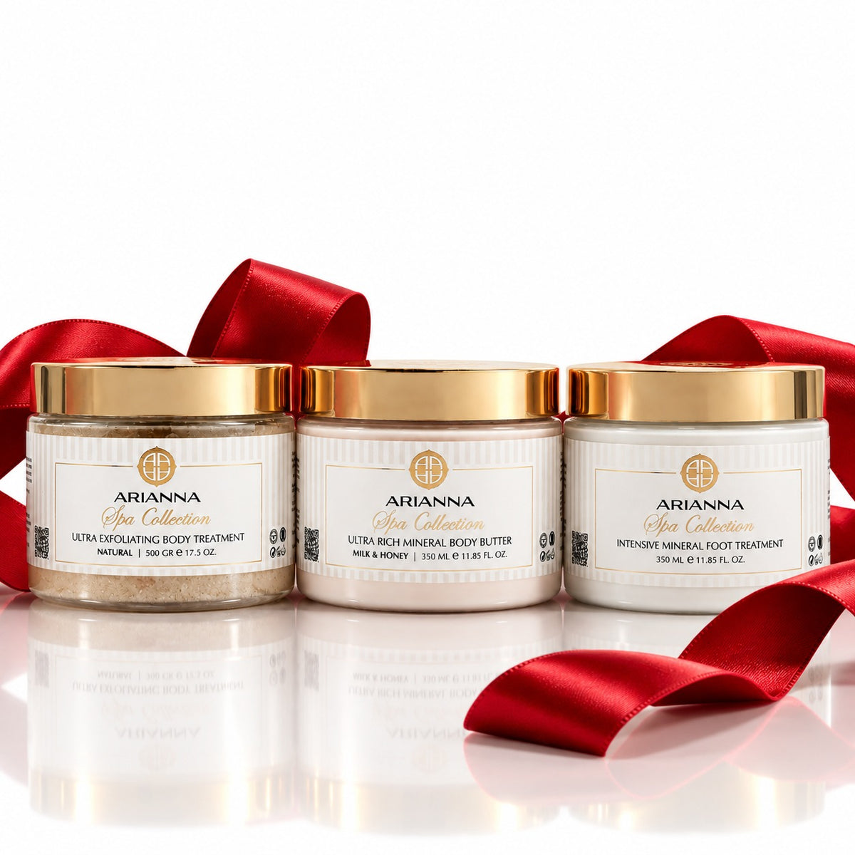 The Body Trio Glow: Ultra Exfoliating Body Treatment, Ultra Rich Mineral Body Butter and Intensive Mineral Foot Treatment with a red satin ribbon