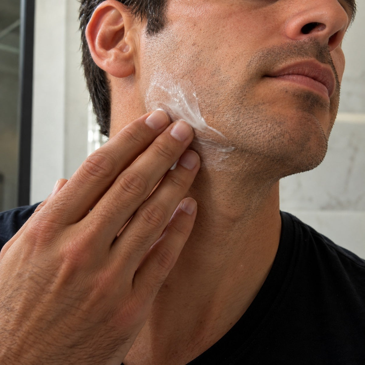 Man applying Arianna Men After Shave Balm to his jaw after shaving